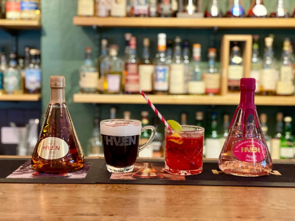 Two bottles of spirits and two drinks on a bar