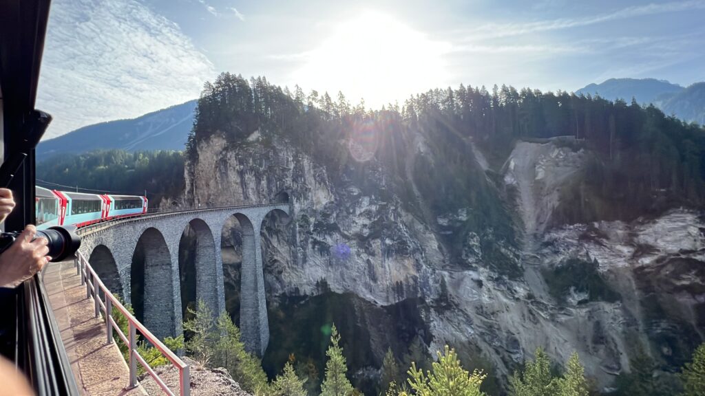 Train going over a viaduct in the mountains.