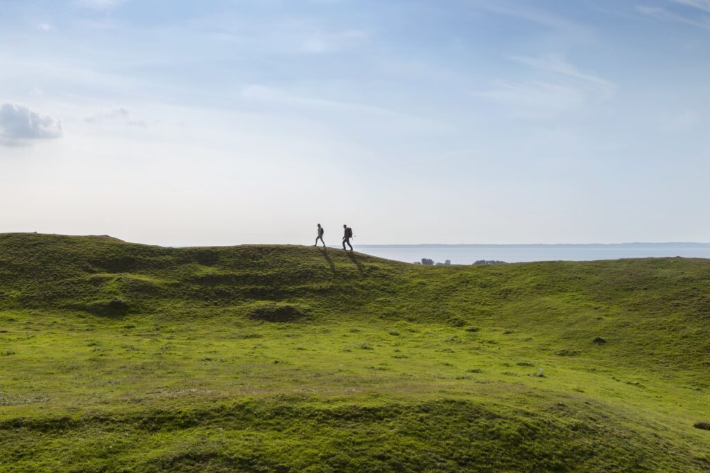 Hiking on rolling green hills with a sea in the background. Båstad, Sweden.