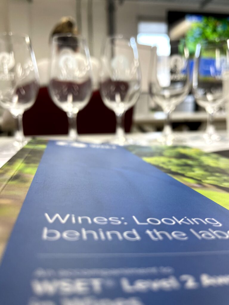 A wine tasting course with glasses lined up on a table.