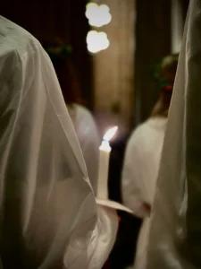 A candle held by a member of the procession