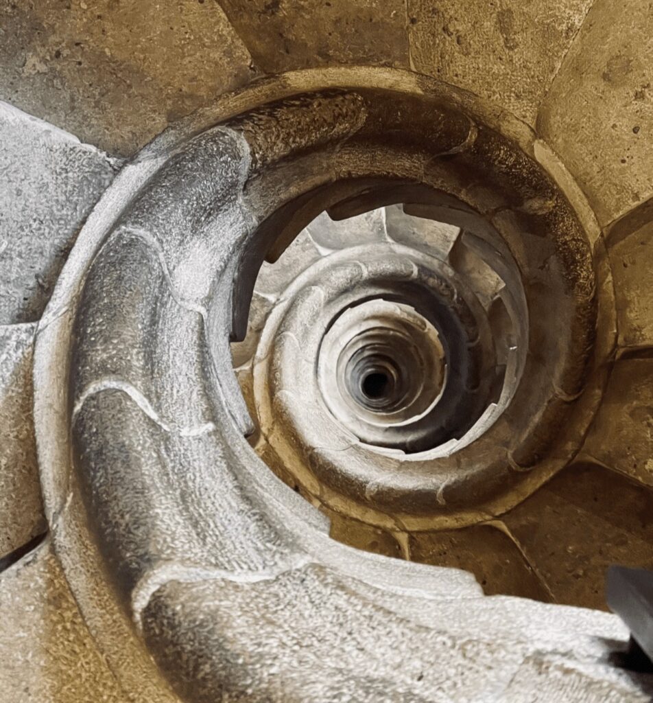 Descending staircase in winding format made out of stone. 