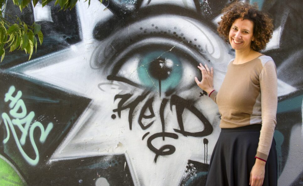 Alternative Athens founder, Tina Sklavolia-Kyriakis posing in front of street art.