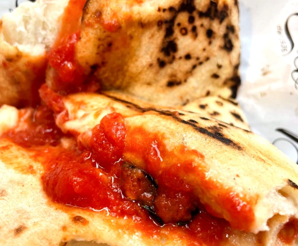 Folded pizza with tomato sauce