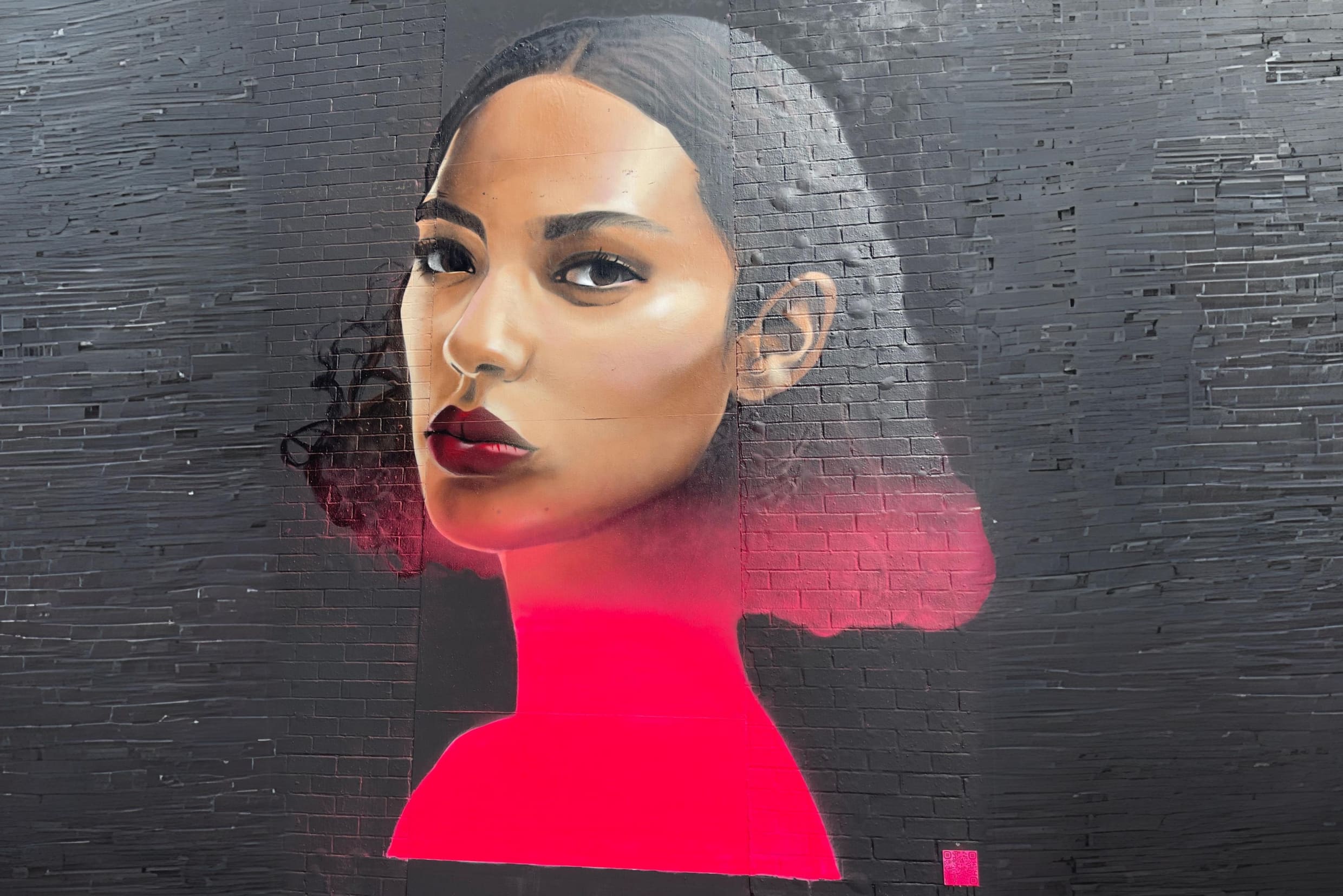 East London street art of a woman's face in black and red colours.