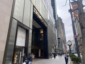 Facade of Trump Tower in New York with people walking in front the of tall building. 