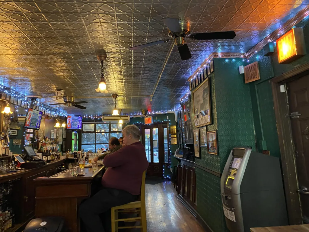Bar area in Neir’s Tavern with customers watching screens behind the bar.