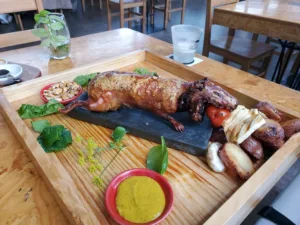 Whole roasted guinea pig on a table in a restaurant.