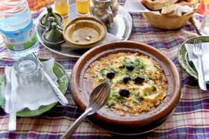 Plate of breakfast dish with olives on top. 