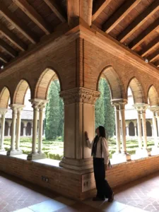 Woman admiring the arches of a cloister inner court. 