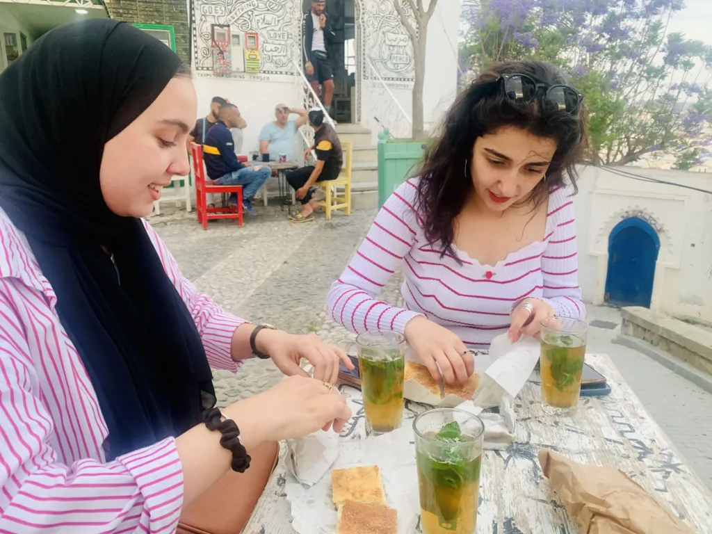 Two women at an outdoor table eating.
