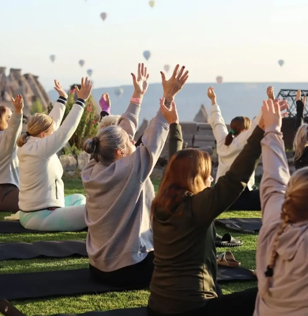 Group of women practicing meditation outdoors.