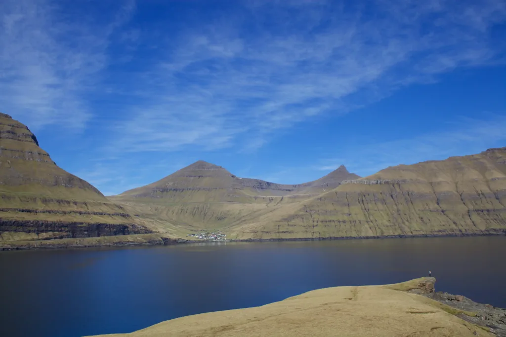 Village at base of mountain by a lake.