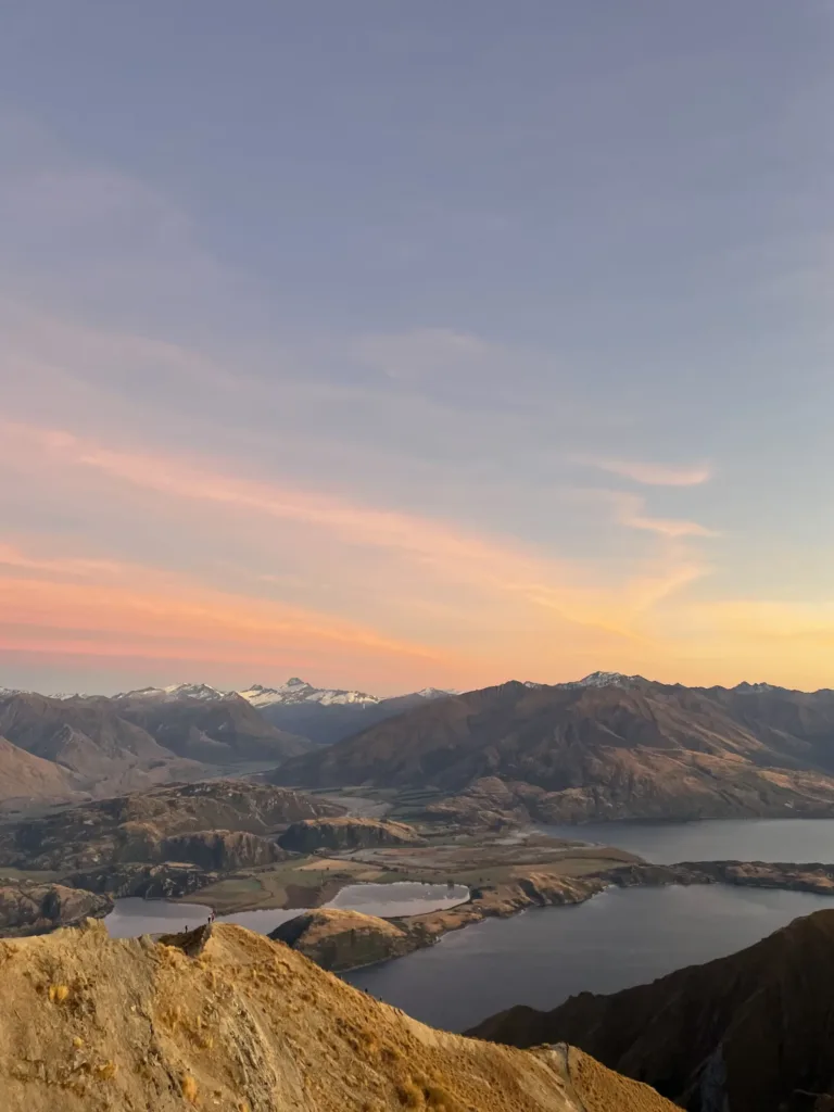 High up view of mountains and lakes amid a sunrise.