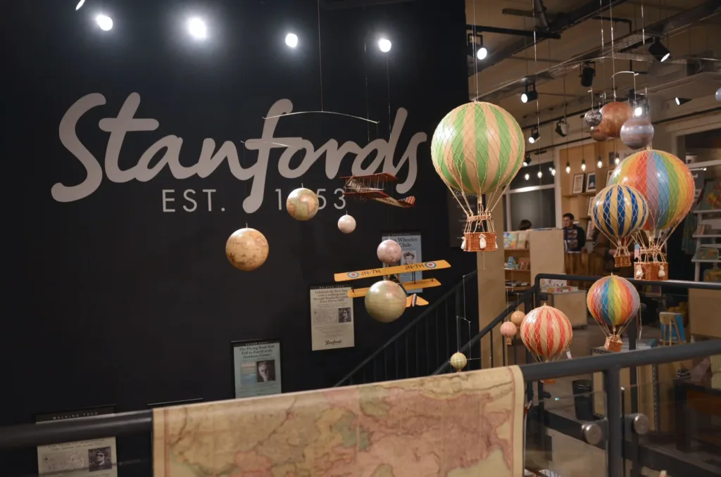 Black wall with the name Stanfords with hot air balloons hanging from the ceiling.