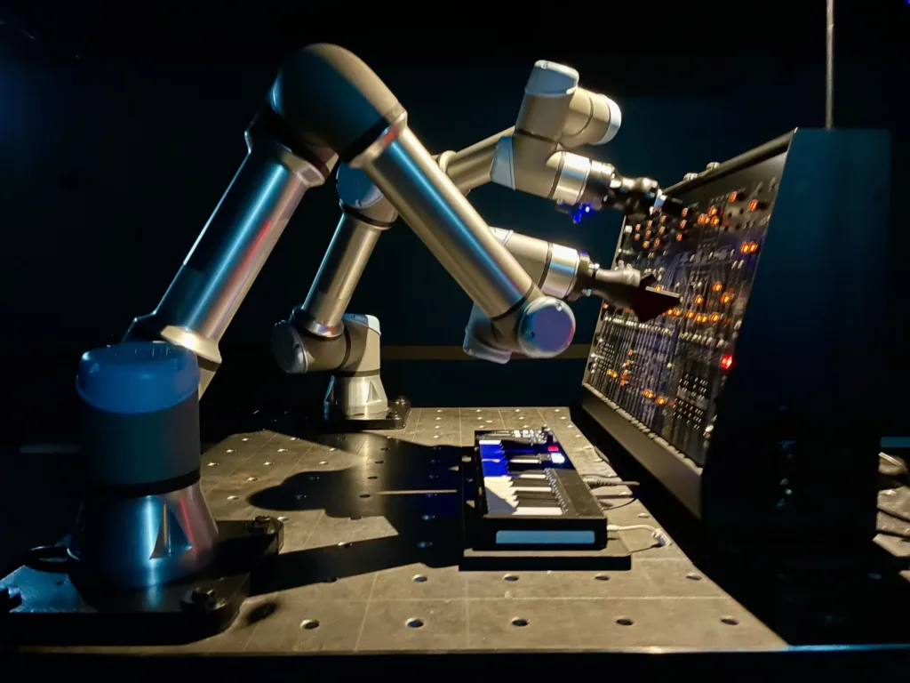 Two robotic arms moving knobs and levers on a music board