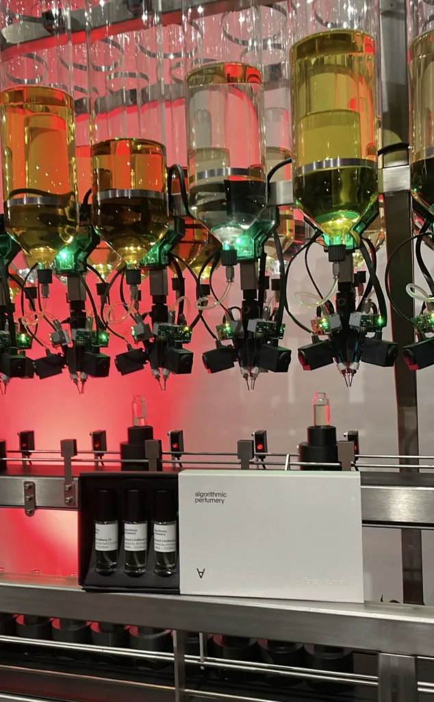 Rows of perfume bottles in a machine controlled by a computer and AI.