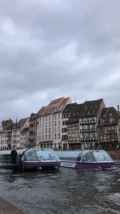 Two canal boats docked along building front