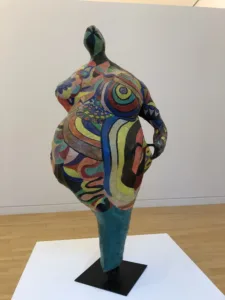 Statue of a woman with exaggerated shapes in various colours.