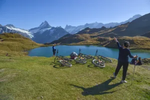 Blue water lake up in the mountains with people and bikes strewn around