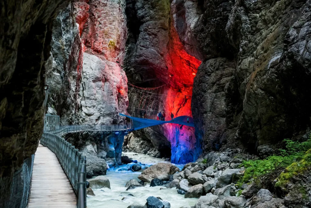 Suspended walkway over a lit ravine.