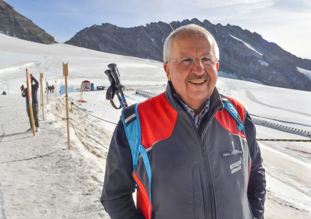 Man posing in front of a skiing track. 