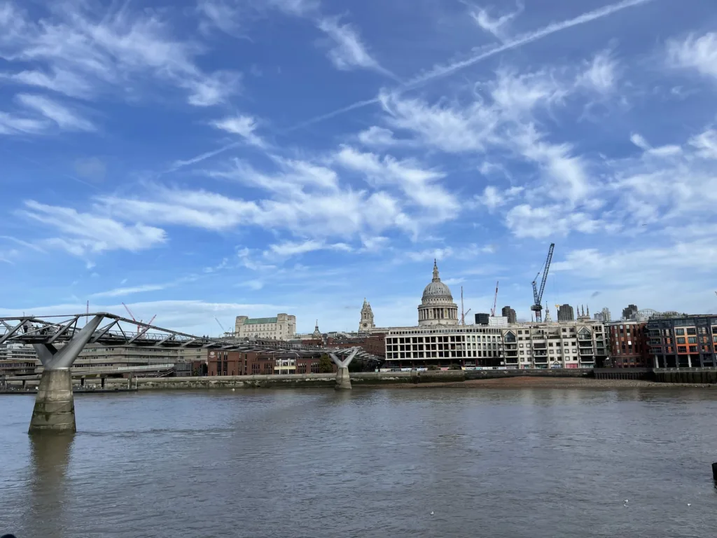 Cathedral across a river with a walking bridge leading to it.