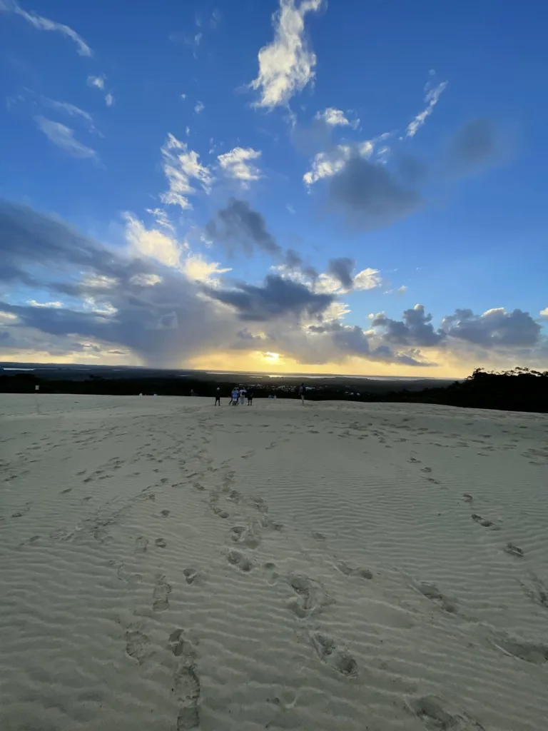 Large sand dune with a group of people on top