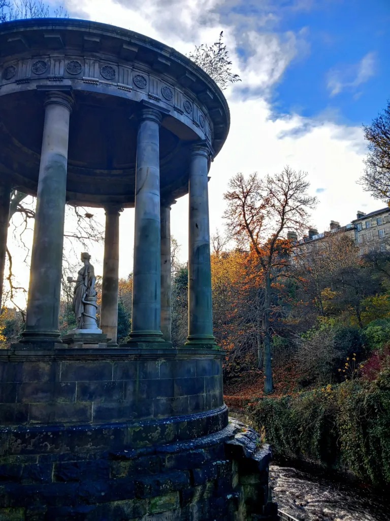 A small stream by a round monument with pillars