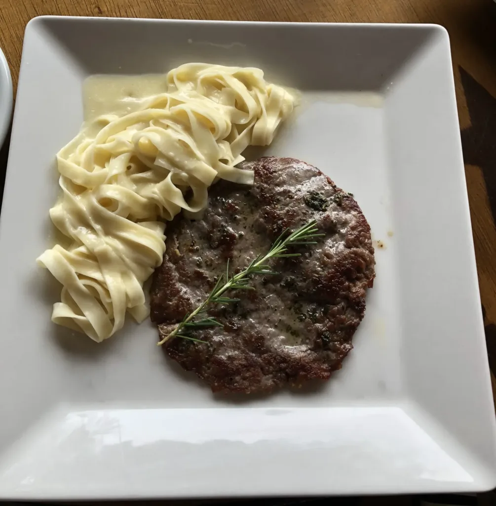 Pasta and meat on a white plate