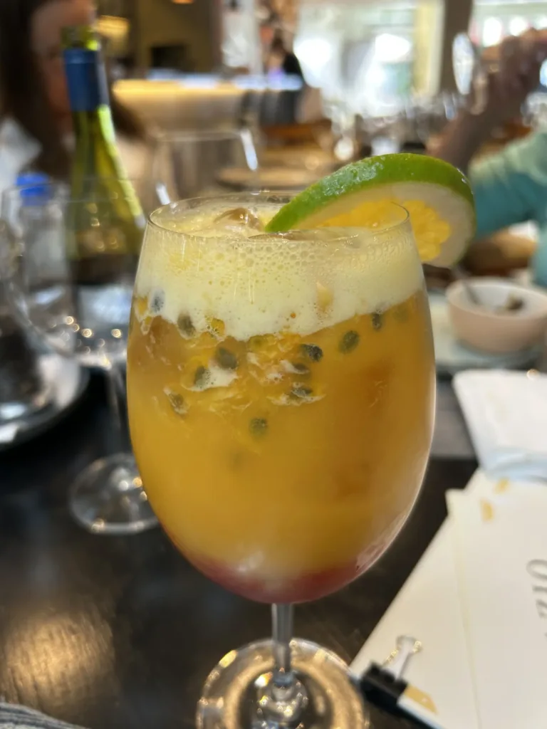 Passion fruit mocktail with a lime wedge standing on a table