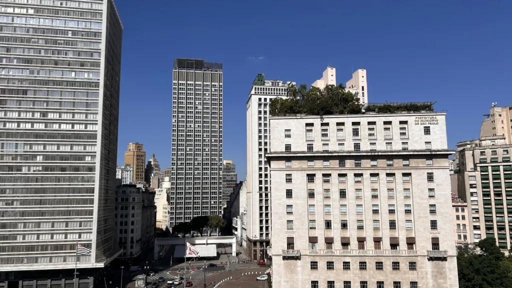 Multi-story white building among high-rises in city landscape
