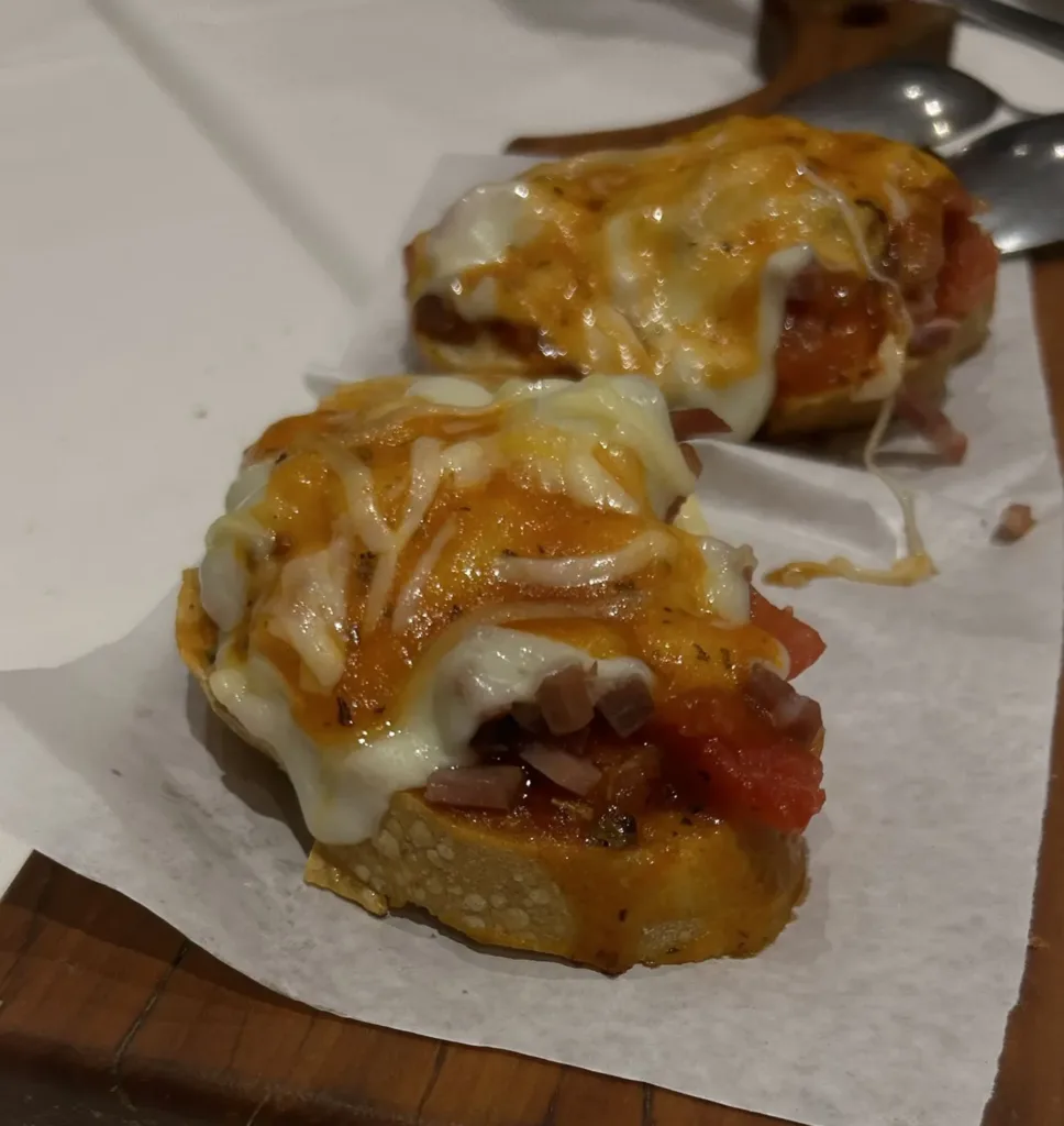 Two Parma Ham bruschettas on a cutting board