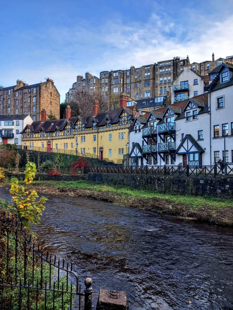 A river running in front of yellow and white houses