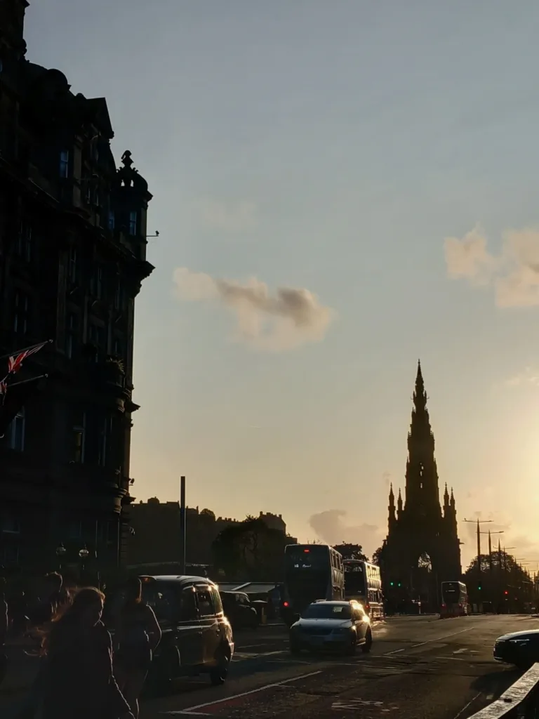 A monument near a street with cars and people
