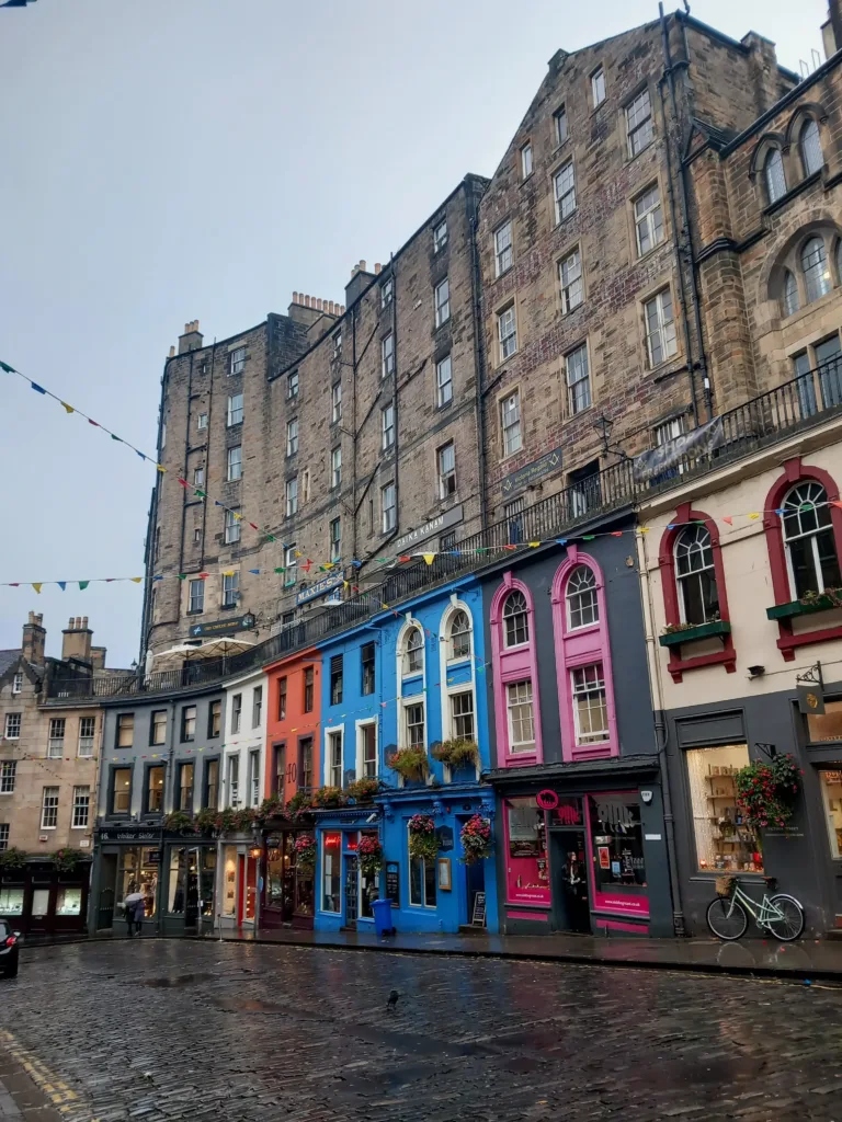Rain soaked street with colourful buildings at street level.
