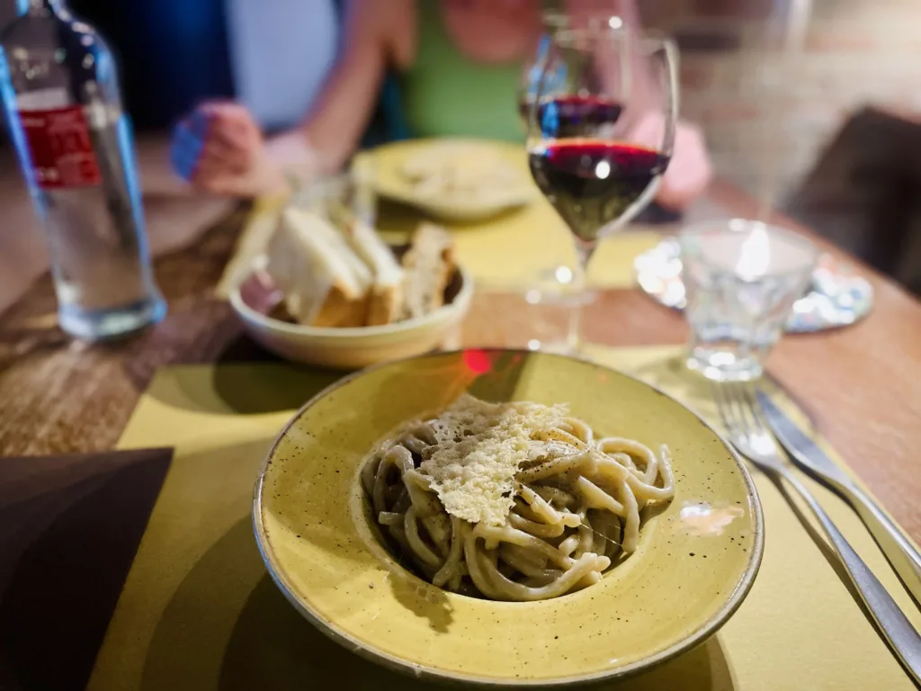 Two plates of pasta and glass of wine in a restaurant