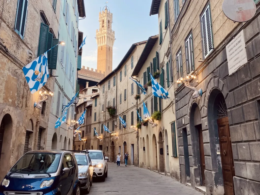 Winding street with blue and white flags hanging from the buildings.