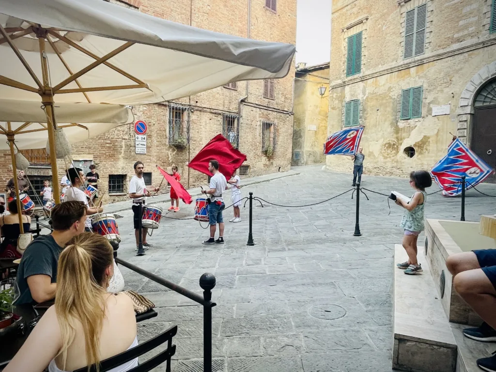 Street performance with drums near a restaurant by a square