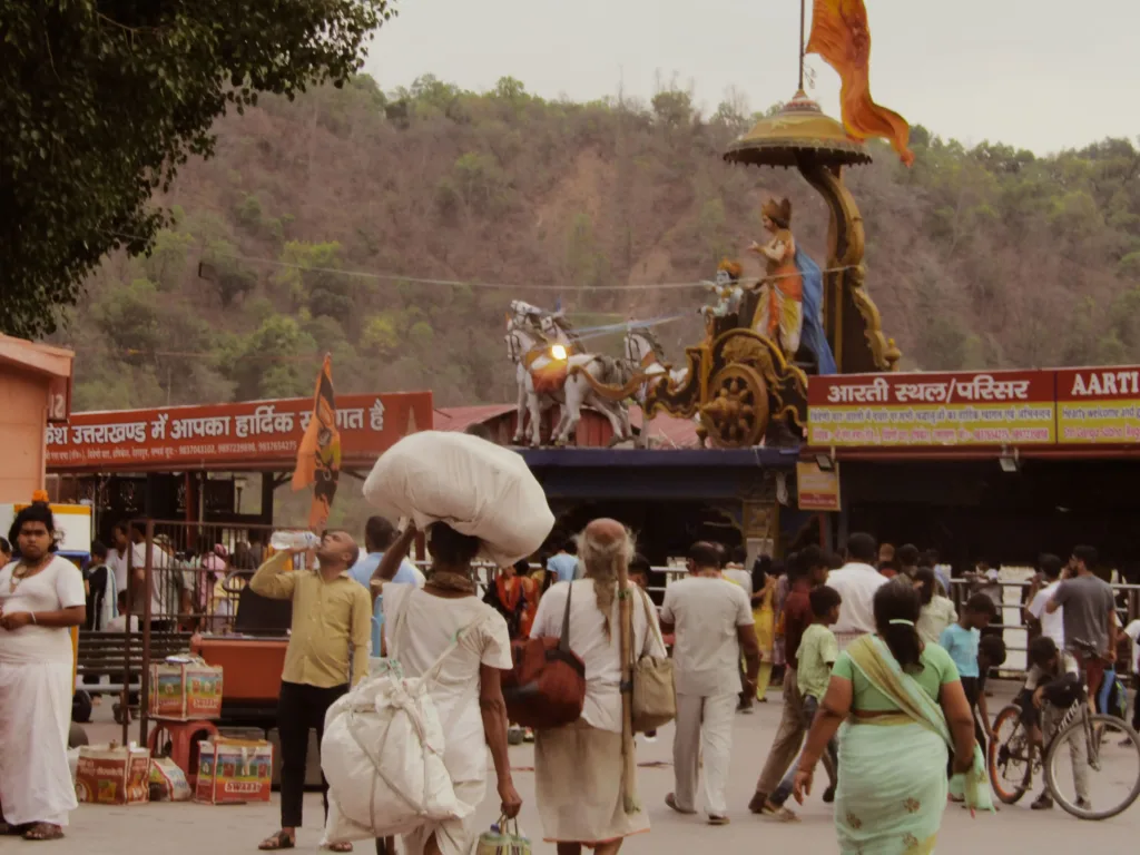 People walking in busy street with bicycles and and market stalls.