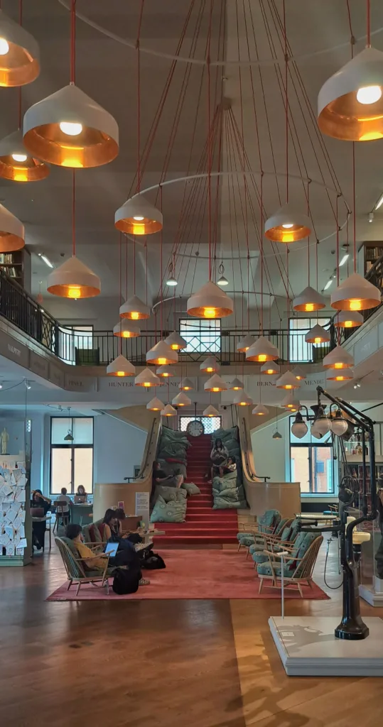 Large room with lamps, staircase filled with large cushions and seating arrangement on a carpet