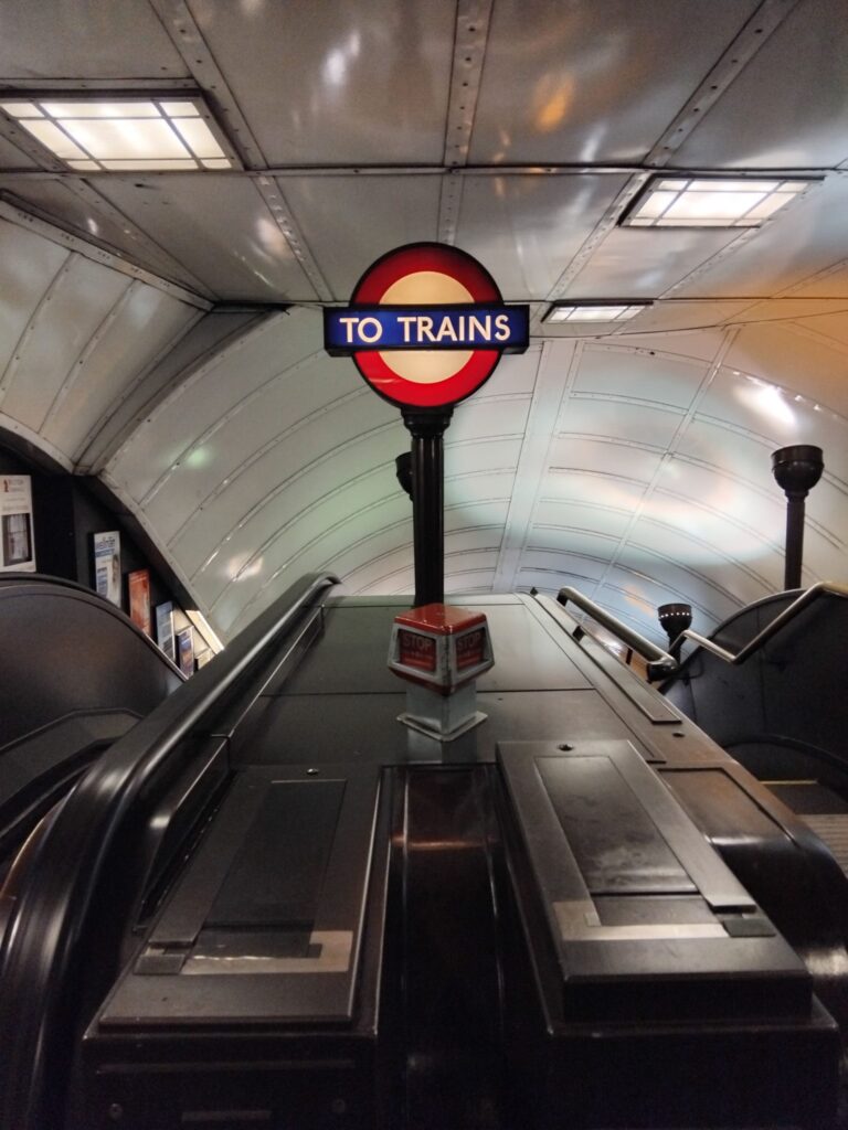 Escalators with sign to the trains