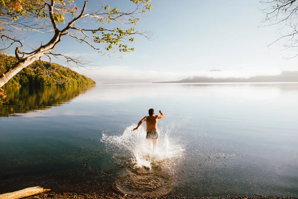 Man running into a lake splashing water