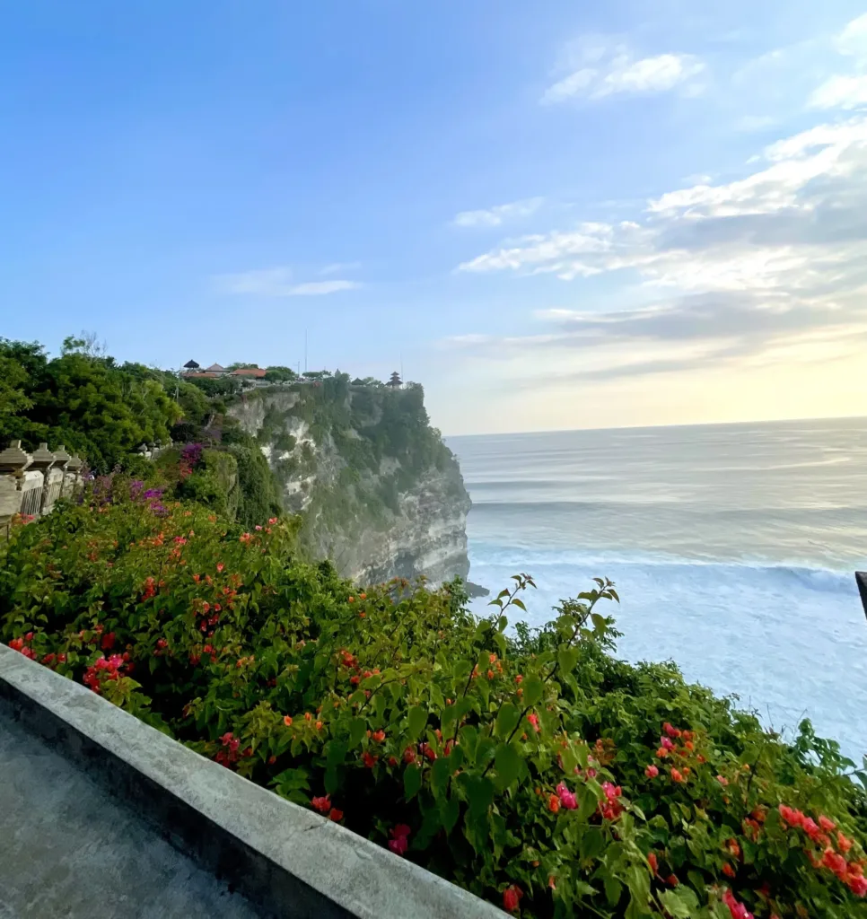 Flowery bushes by cliffside temple
