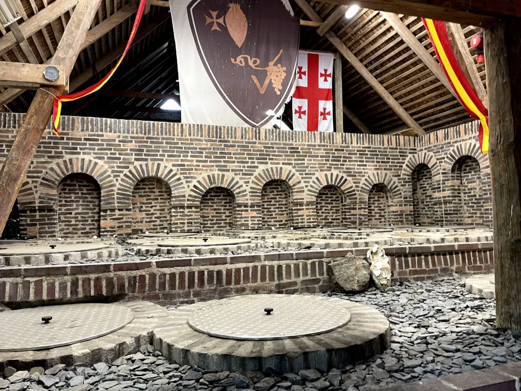 Wine cellar with arches and bricks and wooden ceiling.