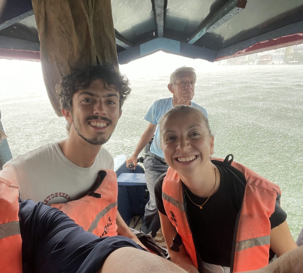 3 people on a boat with rain falling around