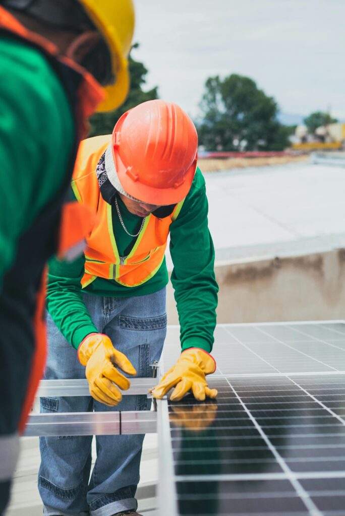 Man in red helmet installing solar panels