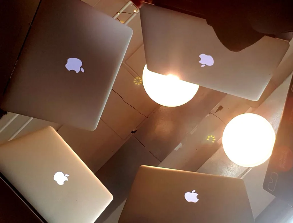 5 laptops huddles close together, seen from below.