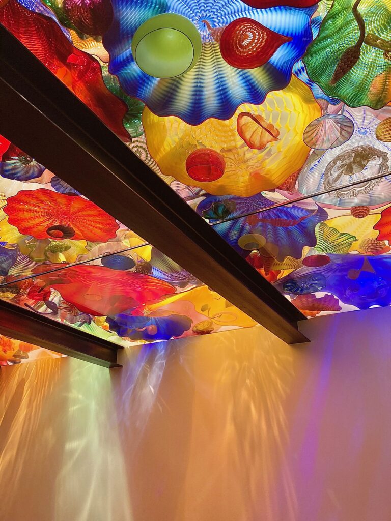 Two steel beams holding up a colourful ceiling of glass