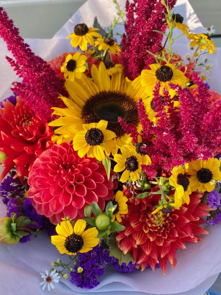 A flower bouquet with sun flowers, and red and purple flowers
